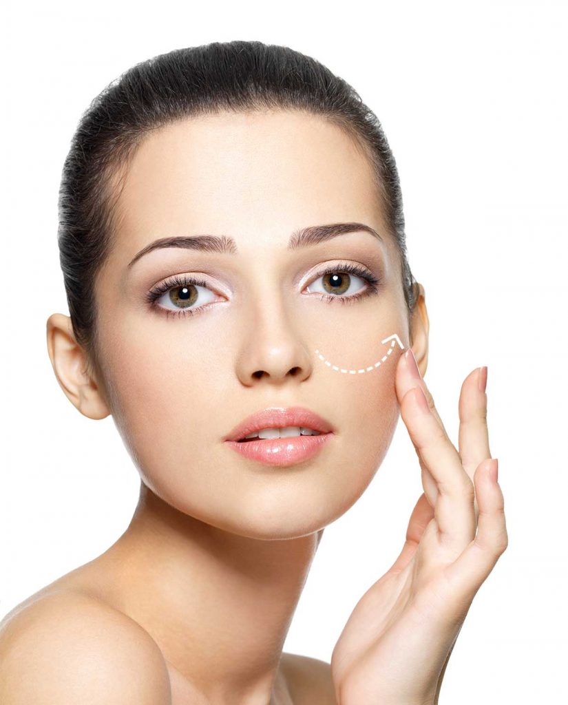 Mujer acariciando su pómulo con el dedo anlar y corazón haciendo referencia al blog de los beneficios de la blefaroplastia